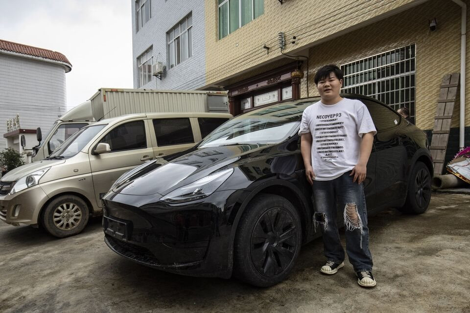 Anh Sun Yajun - con trai ông Sun Hesheng đứng cạnh chiếc xe điện mới.