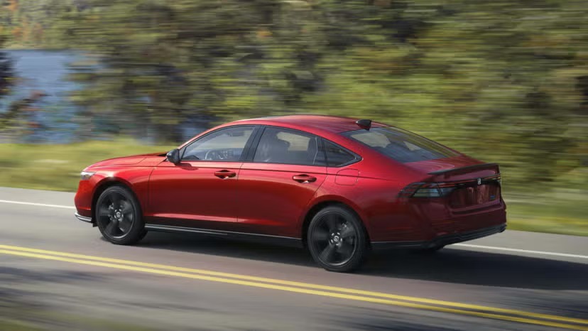 2026-honda-accord-sport-l-hybrid-in-radiant-red-rear-angled-view-driving