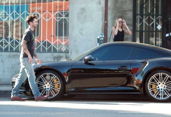 Levine và vợ bước vào chiếc Porsche 911 Turbo S trị giá 182.000 USD