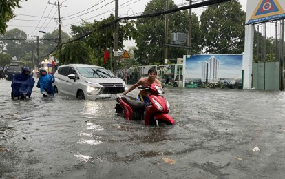 Thành phố Hồ Chí Minh tê liệt vì mưa lớn, người dân bì bõm 'lội nước' đi làm