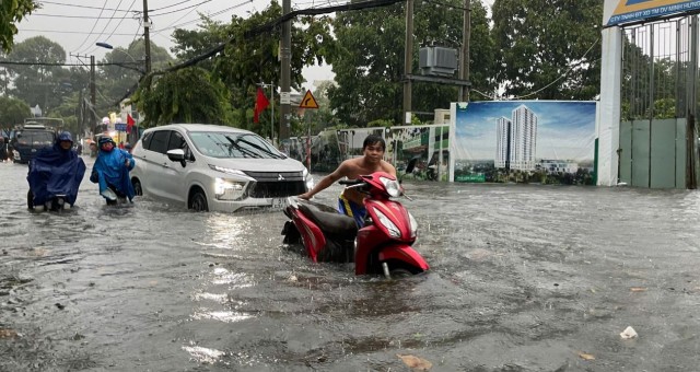 Thành phố Hồ Chí Minh tê liệt vì mưa lớn, người dân bì bõm 'lội nước' đi làm