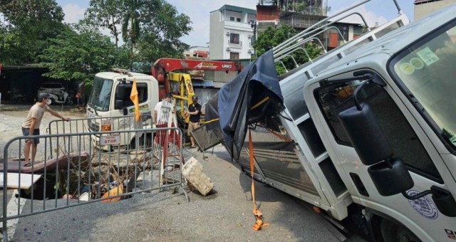 Ô tô tải rơi xuống 'hố tử thần' giữa phố ở Hà Nội, xe cứu hộ đến cũng gặp nạn